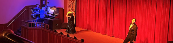 Singers onstage with a red curtain behind them